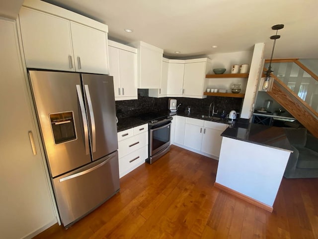 kitchen featuring stainless steel appliances, dark countertops, white cabinets, decorative backsplash, and recessed lighting