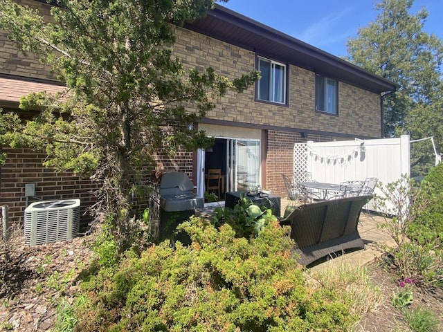 rear view of house with brick siding and central air condition unit