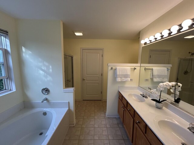 bathroom with a sink, double vanity, a stall shower, and a bath