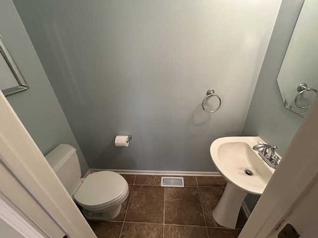 bathroom with a sink, toilet, tile patterned floors, baseboards, and visible vents