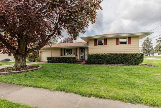 split level home featuring a garage, concrete driveway, and a front yard