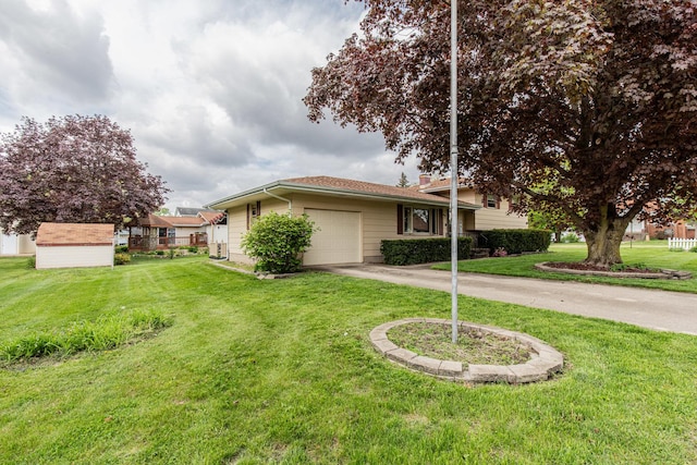 exterior space featuring a lawn, driveway, a storage shed, and a garage