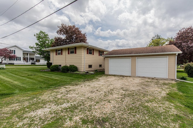 view of side of home featuring a garage, an outbuilding, and a yard