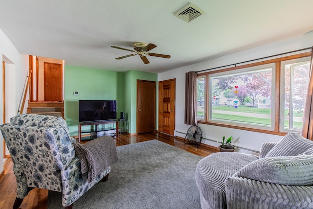 living room featuring visible vents, baseboards, ceiling fan, and wood finished floors
