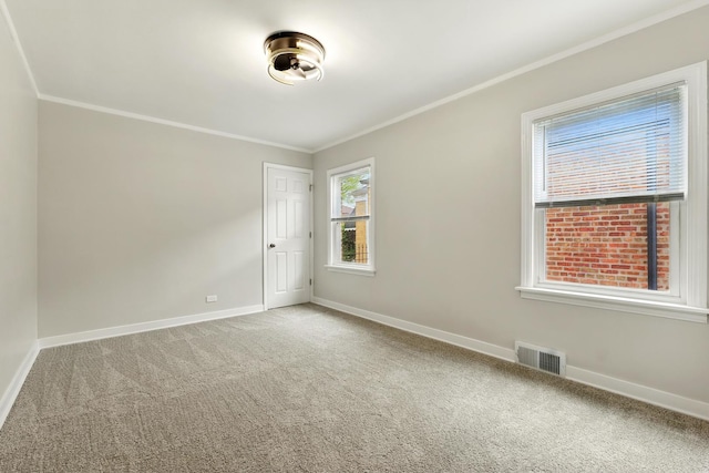 carpeted spare room with visible vents, ornamental molding, and baseboards