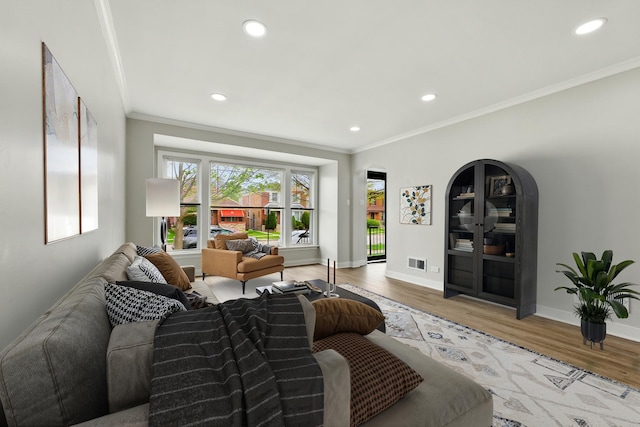 living room featuring crown molding, recessed lighting, wood finished floors, and visible vents