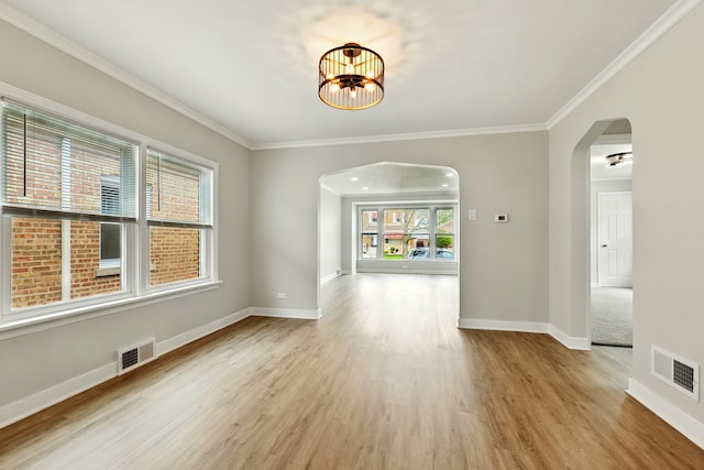 unfurnished dining area with arched walkways, visible vents, and a wealth of natural light