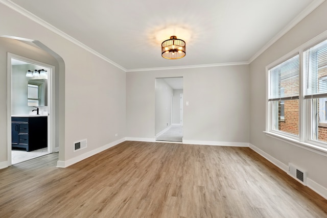 spare room featuring a chandelier, baseboards, visible vents, and light wood-style flooring