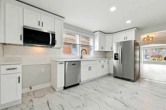 kitchen with white cabinets, appliances with stainless steel finishes, light countertops, recessed lighting, and tasteful backsplash