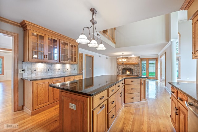 kitchen featuring a kitchen island, open floor plan, light wood finished floors, and a fireplace