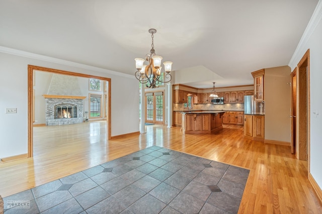 interior space with open floor plan, light wood-style flooring, brown cabinets, and stainless steel appliances