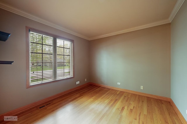 spare room with visible vents, ornamental molding, and wood finished floors