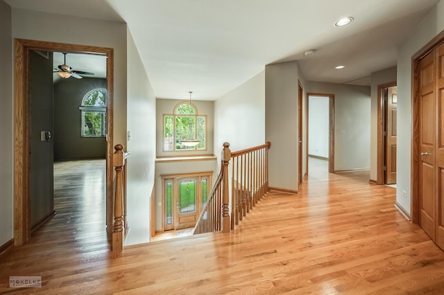 corridor featuring recessed lighting, baseboards, light wood finished floors, and an upstairs landing