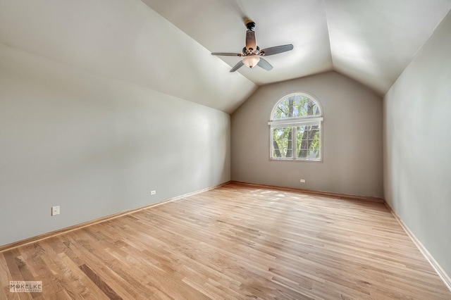 additional living space with light wood-type flooring, a ceiling fan, baseboards, and vaulted ceiling