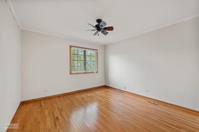spare room with crown molding, ceiling fan, light wood-style flooring, baseboards, and visible vents