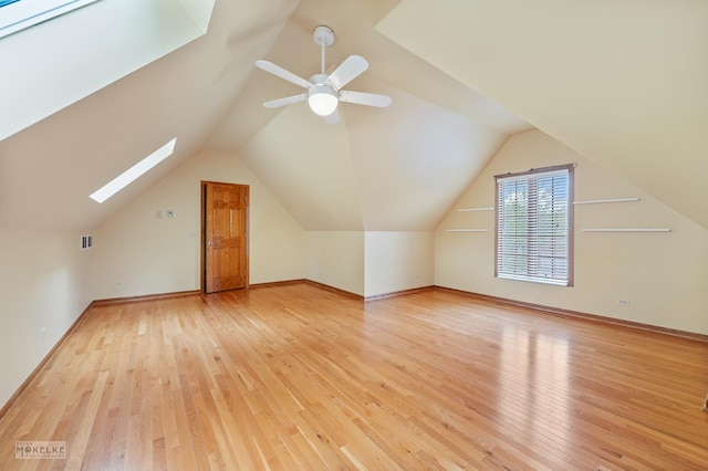 bonus room with visible vents, light wood finished floors, and vaulted ceiling with skylight