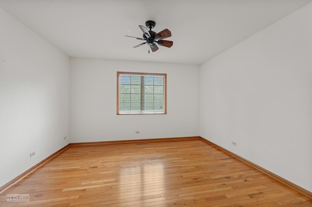 unfurnished room with baseboards, ceiling fan, and light wood-type flooring