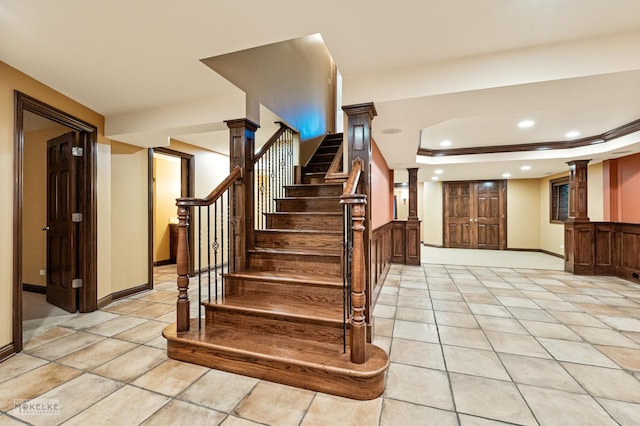 stairs featuring baseboards, tile patterned flooring, a tray ceiling, and recessed lighting
