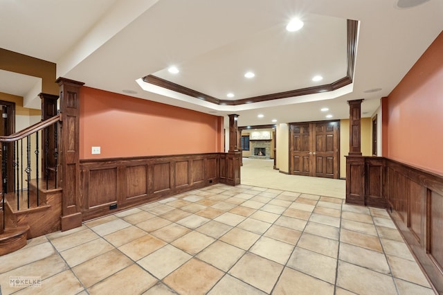 interior space with ornate columns, recessed lighting, wainscoting, and a raised ceiling