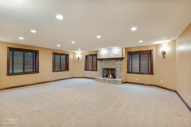 unfurnished living room featuring recessed lighting, baseboards, light carpet, and a fireplace