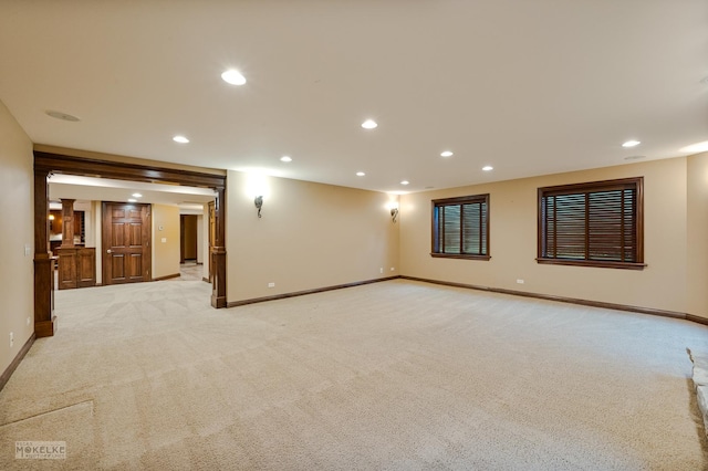 spare room with baseboards, recessed lighting, and light colored carpet