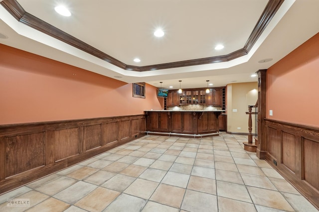 kitchen featuring a wainscoted wall, ornamental molding, a tray ceiling, and recessed lighting