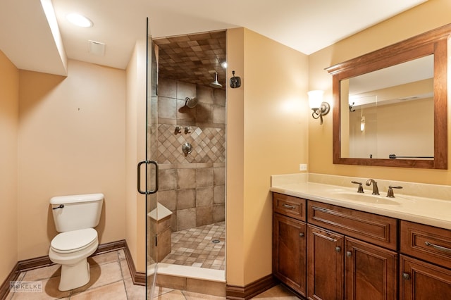bathroom featuring tile patterned flooring, vanity, toilet, baseboards, and a stall shower