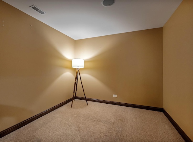 unfurnished room with baseboards, light colored carpet, and visible vents