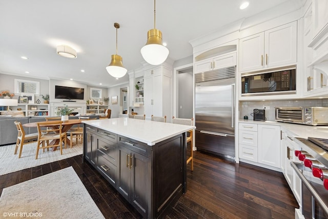 311 E Schiller St, Elmhurst, IL 60126 - kitchen with built in appliances, white cabinetry, ornamental molding, open floor plan, and light countertops