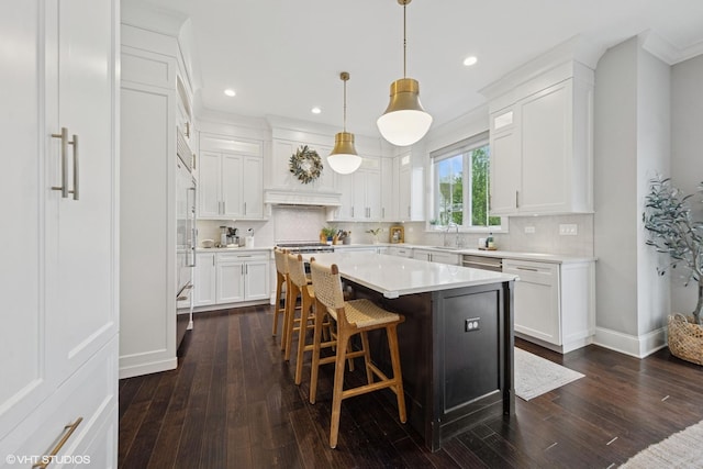 311 E Schiller St, Elmhurst, IL 60126 - kitchen with a kitchen island, white cabinets, light countertops, recessed lighting, and decorative backsplash