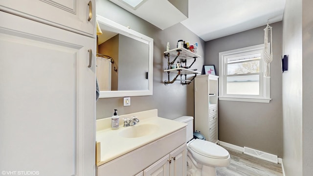2818 Brentwood Dr, Racine, WI 53403 - bathroom featuring wood finished floors, vanity, toilet, and baseboards