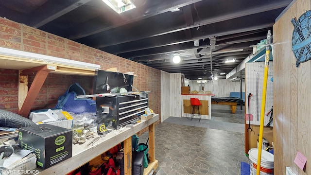 2818 Brentwood Dr, Racine, WI 53403 - finished below grade area featuring a workshop area, stone finish flooring, and brick wall
