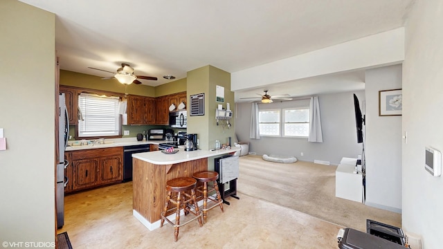 2818 Brentwood Dr, Racine, WI 53403 - kitchen with ceiling fan, black dishwasher, a kitchen breakfast bar, light countertops, and open floor plan
