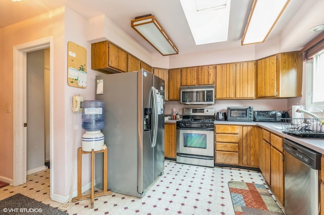 325 Olin Ct, Algonquin, IL 60102 - kitchen featuring stainless steel appliances, a sink, light flooring, light countertops, and brown cabinetry