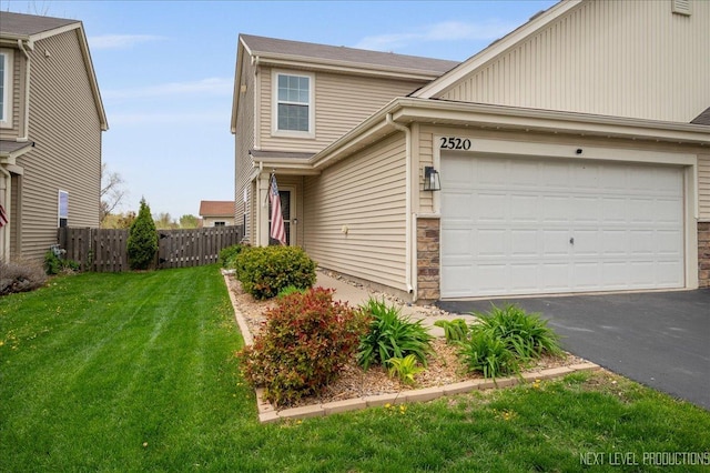 traditional-style home featuring asphalt driveway and an attached garage