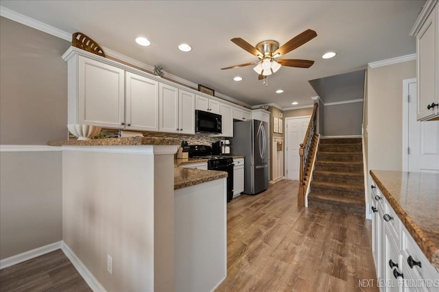 kitchen with black appliances, a ceiling fan, dark stone counters, ornamental molding, and decorative backsplash