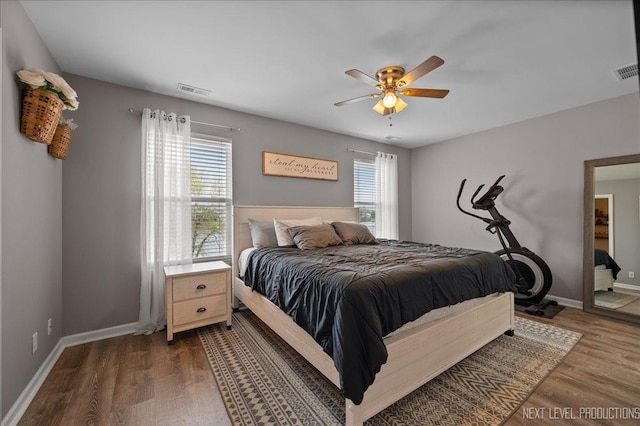 bedroom with dark wood-style floors, baseboards, and ceiling fan