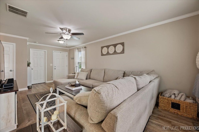 living room with wood finished floors, ceiling fan, crown molding, and baseboards
