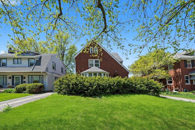 view of front facade with a front yard and a gambrel roof