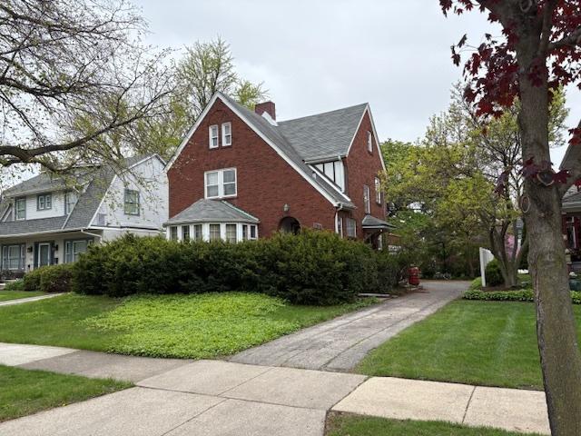 view of front facade featuring a front lawn and a chimney