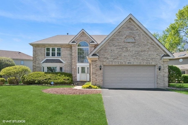 traditional-style home with asphalt driveway, a front yard, brick siding, and a garage