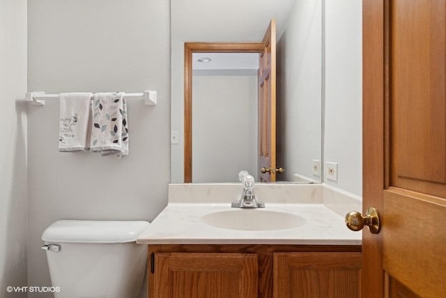 half bathroom with toilet and vanity