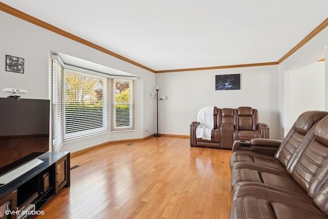 living area with light wood-style flooring, ornamental molding, and baseboards
