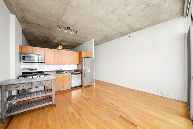 1720 S Michigan Ave Unit 2113, Chicago, IL 60616 - kitchen featuring appliances with stainless steel finishes, light wood-style flooring, decorative backsplash, a ceiling fan, and dark countertops