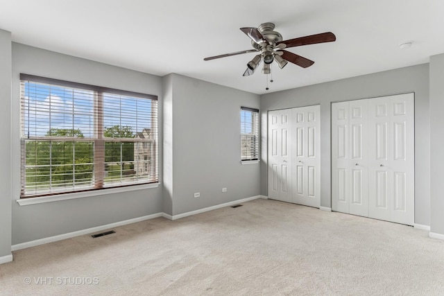 24733 Patriot Square Dr S, Plainfield, IL 60544 - unfurnished bedroom with carpet, multiple closets, baseboards, and ceiling fan