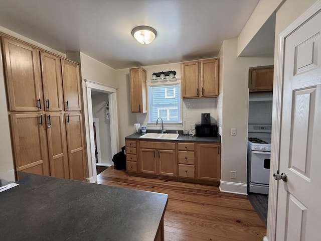 160 S Fordham Ave, Aurora, IL 60506 - kitchen featuring white range with gas stovetop, dark countertops, dark wood-style flooring, and decorative backsplash