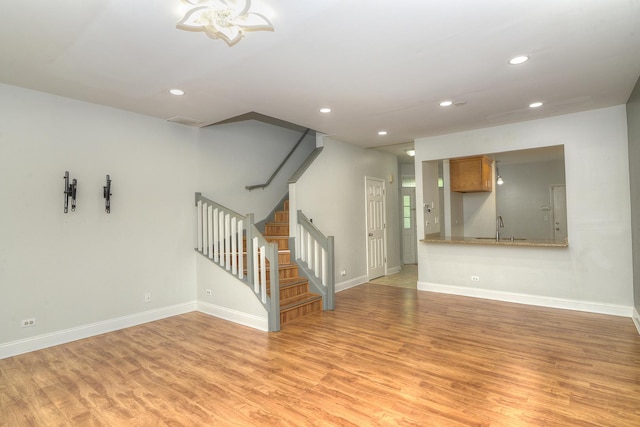 2205 Gladstone Ct, Glendale Heights, IL 60139 - unfurnished living room featuring a sink, light wood finished floors, stairway, recessed lighting, and baseboards