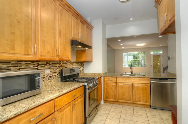 2205 Gladstone Ct, Glendale Heights, IL 60139 - kitchen with stainless steel appliances, a sink, under cabinet range hood, brown cabinets, and light tile patterned floors