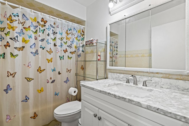 full bathroom with toilet, vanity, and curtained shower