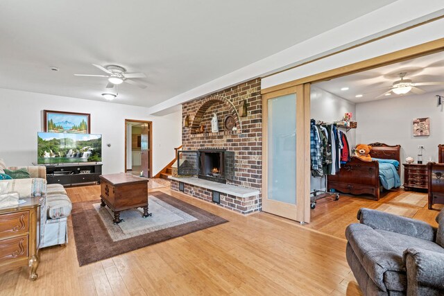 living room with ceiling fan, wood finished floors, and a fireplace
